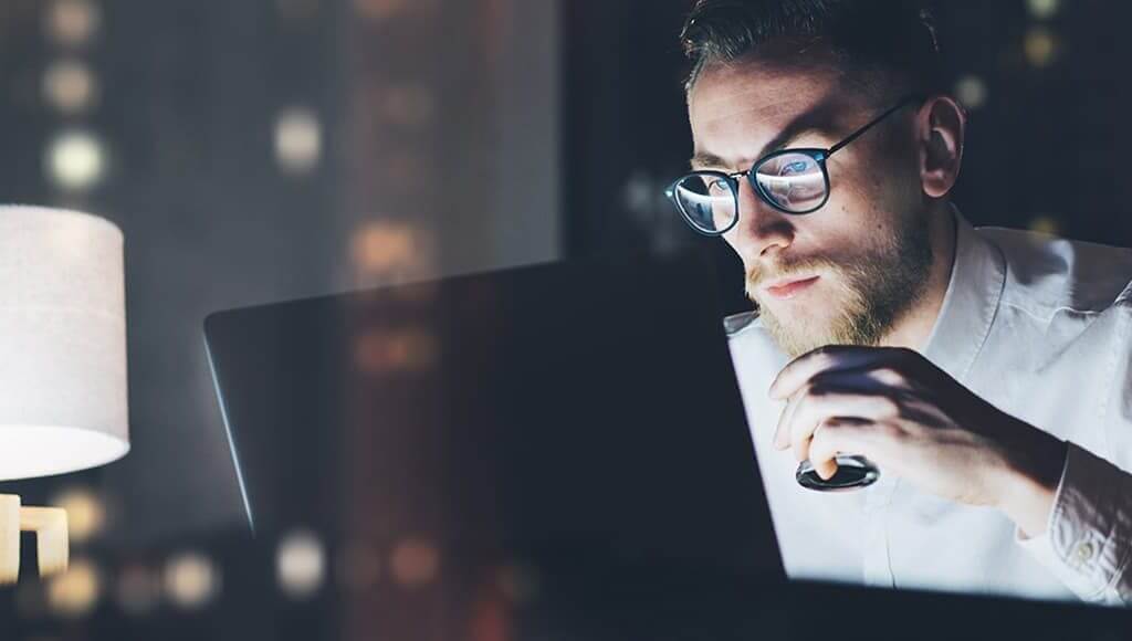 Obstacles You'll Face Starting a Business image - bespectacled man working on a laptop at night