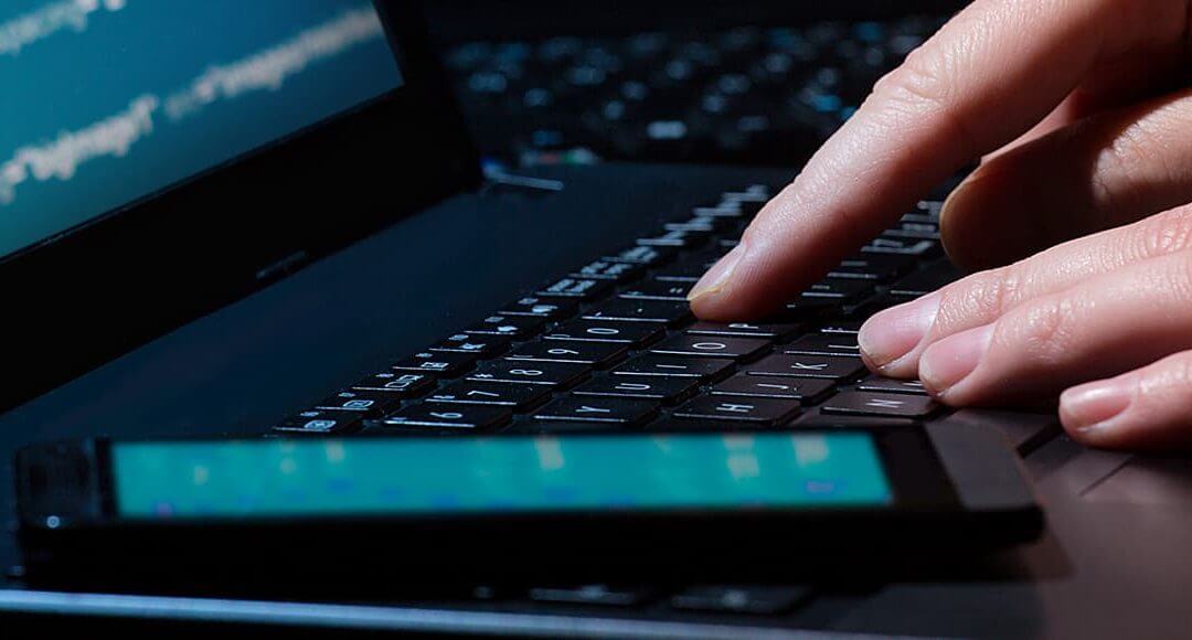 Spot The Red Flags: How To Protect Your Business From Cyberattacks image - hacker typing code into a black laptop