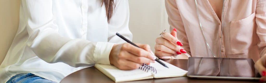 Inspiring girls to Aspire to Entrepreneurship - image - women's hands making notes in a notepad