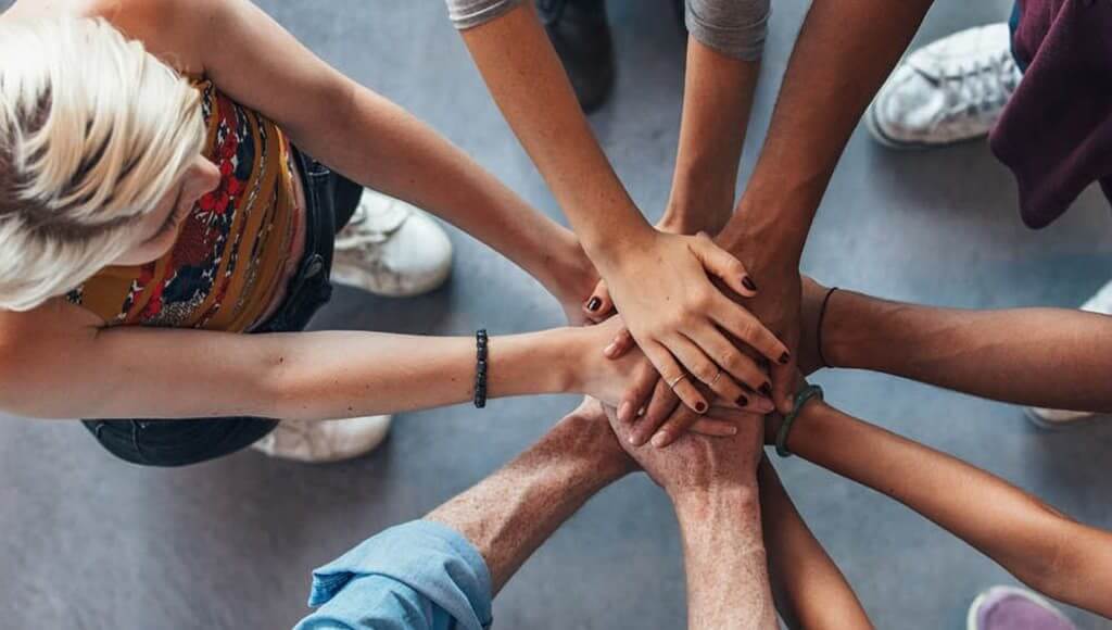 International Women's Day 2017 image - group of people placing their hands together