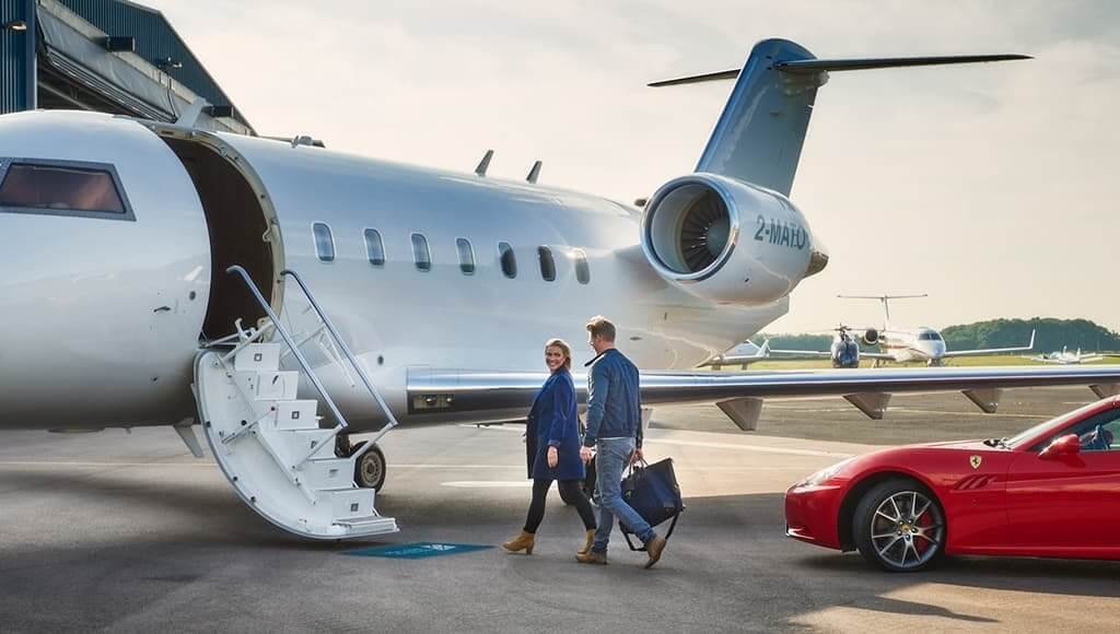 The Startup Journey Of Stratajet CEO And Founder Jonny Nicol image - couple on runway about to walk up steps to an aircraft