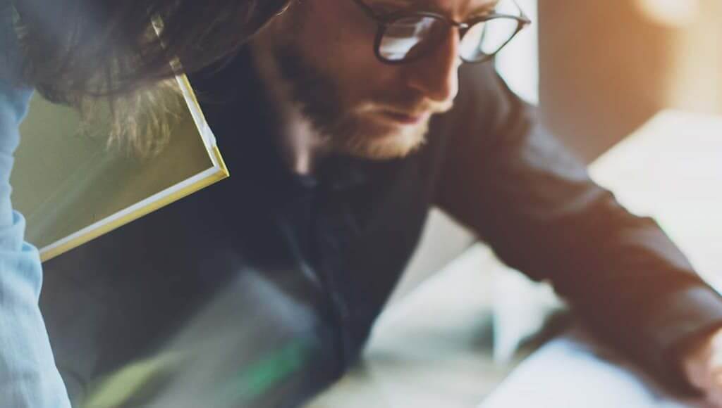 What Does It Mean to be a Project Manager in the Startup World? - image - man at desk with glasses on