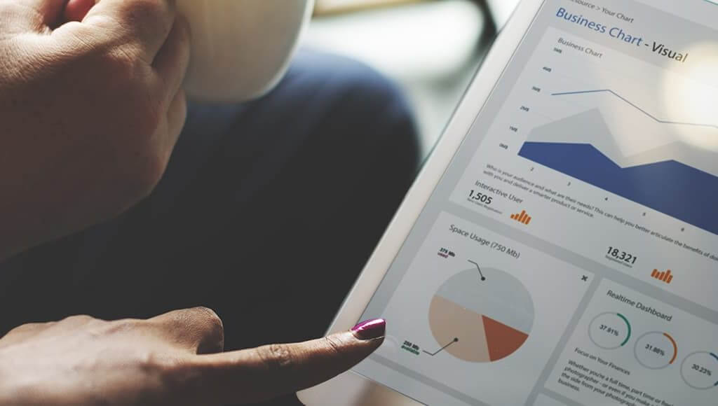 Which Businesses Are Being Invested In the Most - image - hands touching tablet with business charts on screen